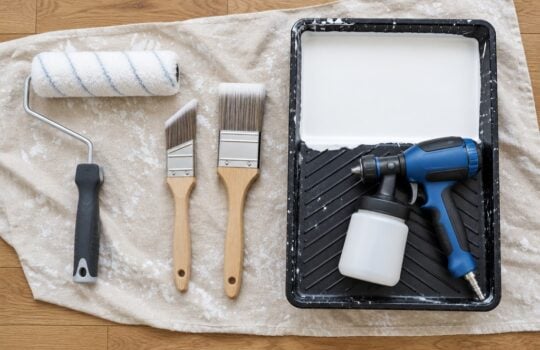 Rullo in microfibra, pennelli e pistola a spruzzo per applicare la pittura